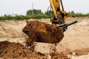 Pre Construction Services | Excavator pulling dirt from the ground | Beausoleil & Sons Paving